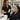 A beauty professional gently removing a client's heavy eye makeup with a cotton round and cleanser at a spa or salon station.