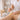 A professional esthetician holding a single-use wooden spatula, ready to apply wax from a professional wax warmer, emphasizing no-double-dipping hygiene practices in a modern spa setting.