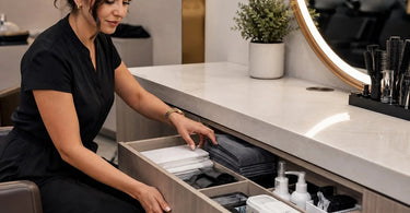 Organized spa treatment room with cleaning supplies hidden in stylish cabinet, featuring Pure Spa Direct products