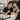 A professional nail technician applying cuticle oil to a client's nails with a precision dropper for a clean and hygienic manicure service.