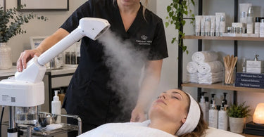 Professional facial steamer in a spa treatment room with adjustable arm and focused steam nozzle