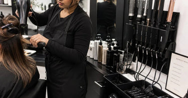 A well-organized salon station with hot tools neatly arranged in a caddy, ready for a busy day of blowouts.