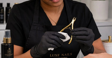 A professional holding a gold-plated cuticle nipper, demonstrating proper care and maintenance techniques for the finish.