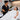 A professional esthetician in a clean spa room performing a body waxing service on a client with a focus on maintaining modesty and comfort.