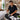 Professional mobile massage kit organized on a portable massage table featuring oils linens and hot stone equipment