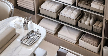 A neatly organized linen closet for a spa, with stacks of towels sorted and labeled by service type such as massage, facial, and waxing.