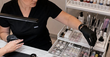 A neatly organized nail art station featuring clear storage containers, a professional manicure desk, and colorful polish displays, showcasing an efficient workspace for salon professionals.