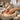 A spa professional performing a luxury paraffin wax manicure, dipping a client's hand into warm, melted wax at a beautifully organized nail station.