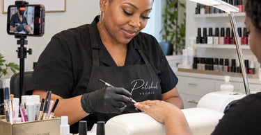 Beauty professional managing appointment schedule while client films social media content in a modern spa treatment room