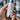 Close-up of a professional aesthetician's hands holding a skincare bottle, pointing to the ingredient label with a client looking on.