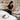A neatly organized spa treatment room featuring a facial bed, a fully stocked rolling cart, and various professional supplies like towels and skincare products.