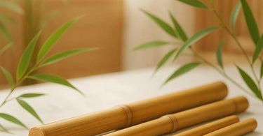 Professional bamboo massage sticks for deep tissue therapy, shown with spa towels and massage oil