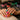 Close-up of a nail technician applying vibrant dip powder to a client's nails for a flawless manicure