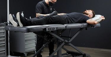 Hydraulic tattoo bed in a professional studio setting, showcasing adjustable features and sleek design