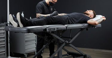 Hydraulic tattoo bed in a professional studio setting, showcasing adjustable features and sleek design