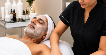 Spa professional giving a relaxing hand and arm massage to a client during a facial mask processing time to enhance relaxation and service value.