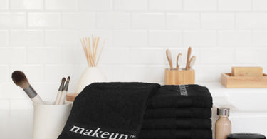 Black makeup washcloths with white lettering by the Turkish Towel Company, ideal for spas and hotels.