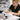 Nail technician extending short nail bed with gel application at salon station