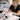 Nail technician extending short nail bed with gel application at salon station