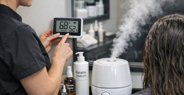 A professional stylist using a flat iron on a keratin hair treatment while a digital hygrometer displays perfect humidity levels in the background.
