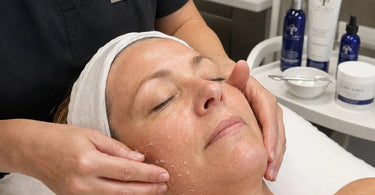 Esthetician applying finishing facial products with a gentle patting motion to prevent product pilling on client's skin