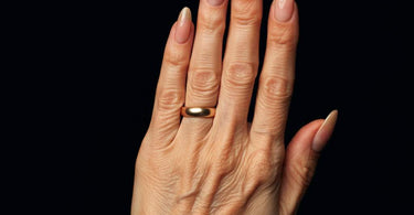 Neutral manicure on older hand, demonstrating a flattering oval nail shape.