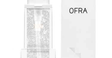 OFRA Cosmetics Silicone Primer tube held against a smooth, poreless, flawless skin background, representing a perfect makeup base for salon and spa professionals.