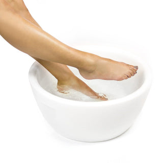 White resin pedicure bowl with feet soaking, showcasing a luxurious spa pedicure setup.