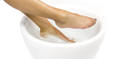 White resin pedicure bowl with feet soaking, showcasing a luxurious spa pedicure setup.