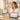 A smiling spa owner in a white coat confidently explaining a new price list to a happy client in a bright, modern salon, illustrating a smooth price increase conversation.