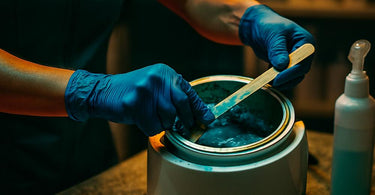 Professional wax warmer with hard wax being removed using a spatula
