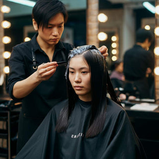 Client at salon receiving hair dye application