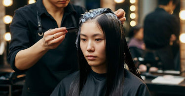 Client at salon receiving hair dye application