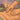 Close-up of a therapist's hands performing cross-fiber friction massage on a client's scar tissue on their back
