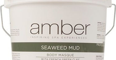 A professional holding a large one gallon jar of Seaweed and French Green Clay Mud Masque by Amber Products, showing the green texture of the spa mud.