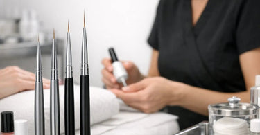 Nail Technician holding a selection of professional nail art striper brushes against a gradient purple background.