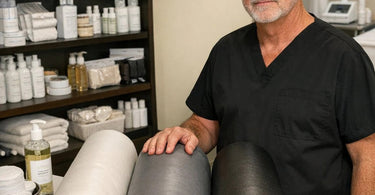 Assorted massage bolsters of varying densities displayed on a professional massage table for post-surgical lymphatic drainage support.