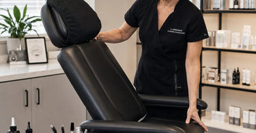 A client comfortably reclined in a professional lash and brow chair during a tinting service, showcasing the optimal angle for treatment.
