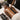 A professional massage therapist carefully selects a basalt hot stone by diameter for placement along a client's spine, symbolizing precision and therapeutic expertise in a spa setting.