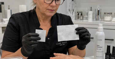 Assorted sizes of lint-free wipes for sticky layer removal on a salon counter with nail polish and tools.
