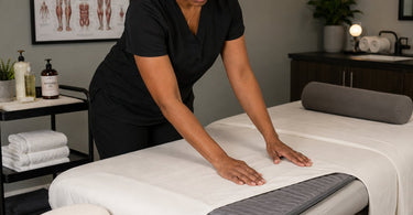 Massage table with a blue table warming pad, perfect for deep tissue work to keep clients warm and muscles pliable