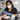 Nail technician wearing a protective mask while filing acrylic nails at a salon station