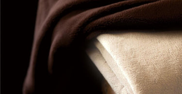 Sposh Chelour Blanket in various colors displayed in a spa setting