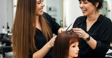 A stylist practicing hair techniques on a mannequin head