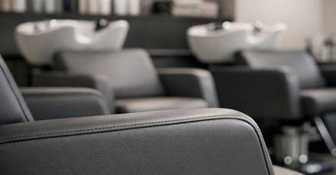 A modern, white salon chair with anti-microbial finish in a bright, clean studio, representing the new standard in spa hygiene and infection control.