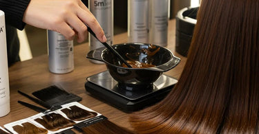 Professional stylist mixing 5N hair color in a salon setting