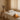 A spa professional smiling while holding a tablet, symbolizing warm and modern client communication in a relaxing wellness setting.