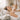 A spa professional gently performing a warm, waterless cleansing treatment for a client in a comfortable bedside setting, featuring no-rinse products and soft towels.