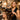 A professional hairstylist demonstrating the use of a blow-dry brush on a client's hair in a modern salon setting.