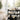 A professional, organized high-end spa trolley system fully stocked with massage oils, waxing supplies, and skin care products in a modern treatment room.
